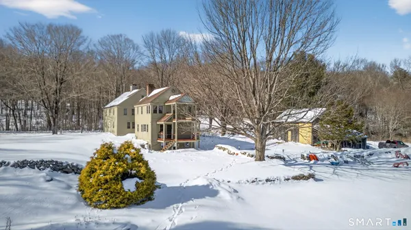 a front view of a house with a yard covered in snow