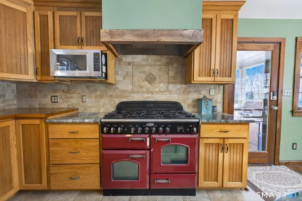 a kitchen with granite countertop a stove and a wooden cabinets