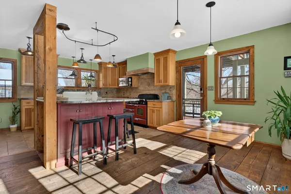 a view of a dining room and livingroom with furniture wooden floor a chandelier