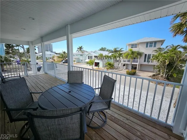 a balcony with couple of chairs and wooden floor