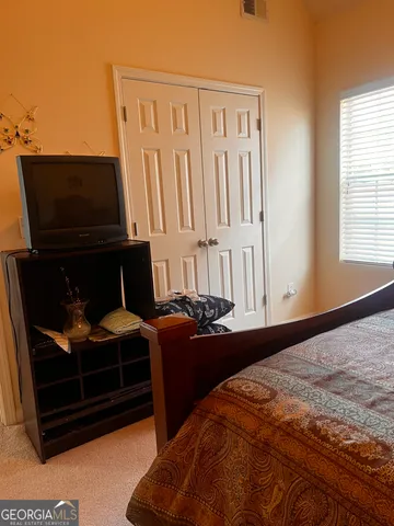 a bedroom with furniture and flat screen tv