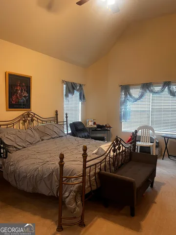 a bedroom with a bed window and couch