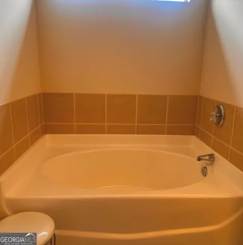 a bathroom with a bathtub and toilet