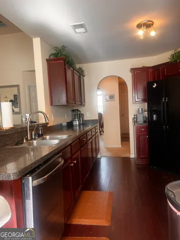 a kitchen with stainless steel appliances granite countertop a sink a stove and a refrigerator