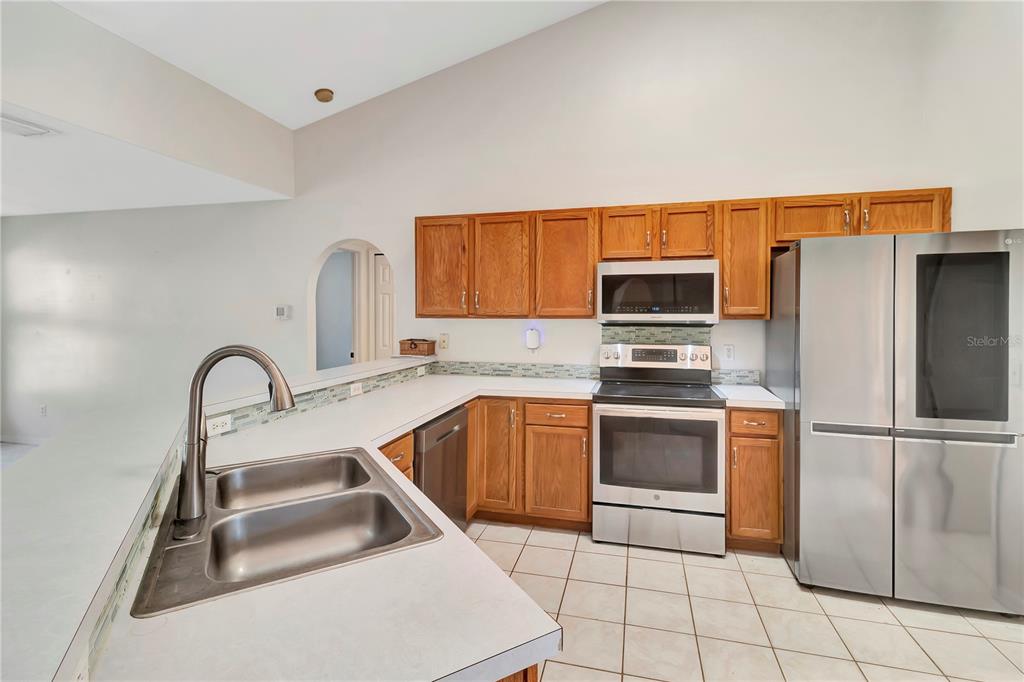 18611 Clark Road Altoona, FL 32702 - Photo 23 of 48 a kitchen with stainless steel appliances granite countertop a sink a stove a refrigerator a microwave and cabinets