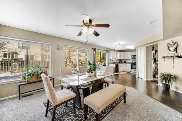 a dining room with wooden floor and a ceiling fan