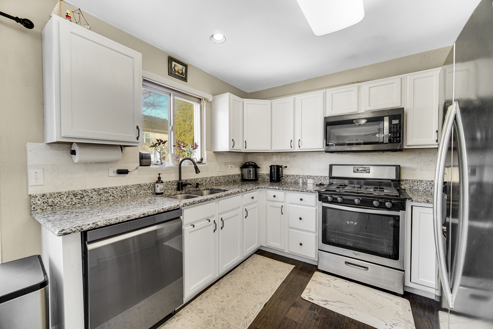 1384 Roxbury Drive Aurora, IL 60502 - Photo 7 of 24 a kitchen with stainless steel appliances granite countertop a sink stove microwave and refrigerator
