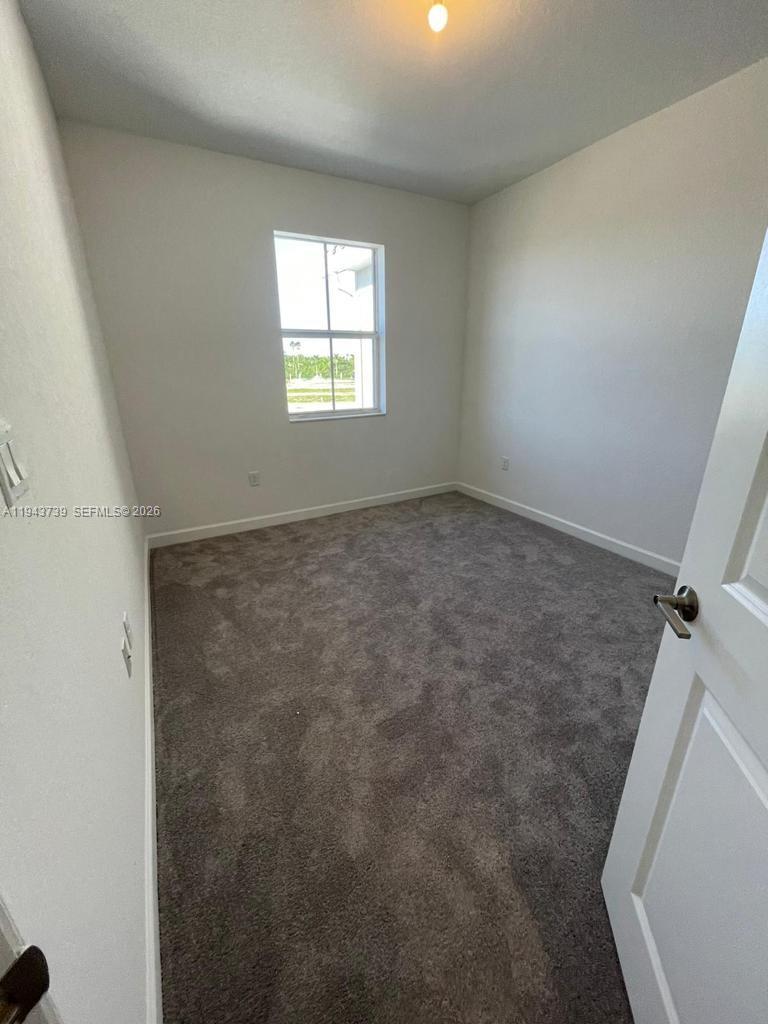 2634 Southeast 11th Court, Unit 2634 Homestead, FL 33035 - Photo 12 of 20 an empty room with windows