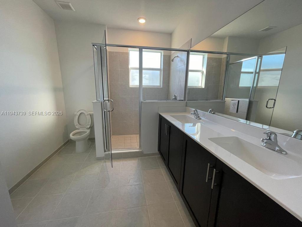 2634 Southeast 11th Court, Unit 2634 Homestead, FL 33035 - Photo 18 of 20 a bathroom with a double vanity sink toilet and shower