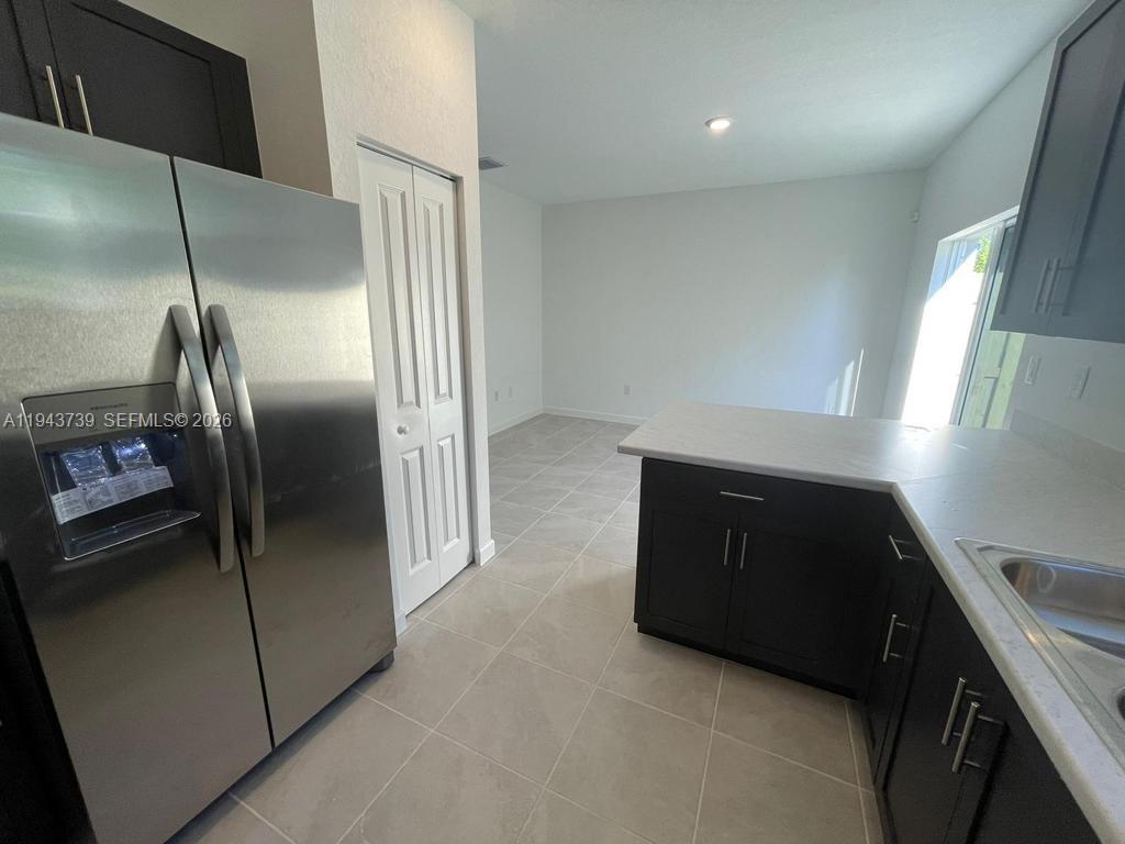 2634 Southeast 11th Court, Unit 2634 Homestead, FL 33035 - Photo 2 of 20 a kitchen with a refrigerator and a sink