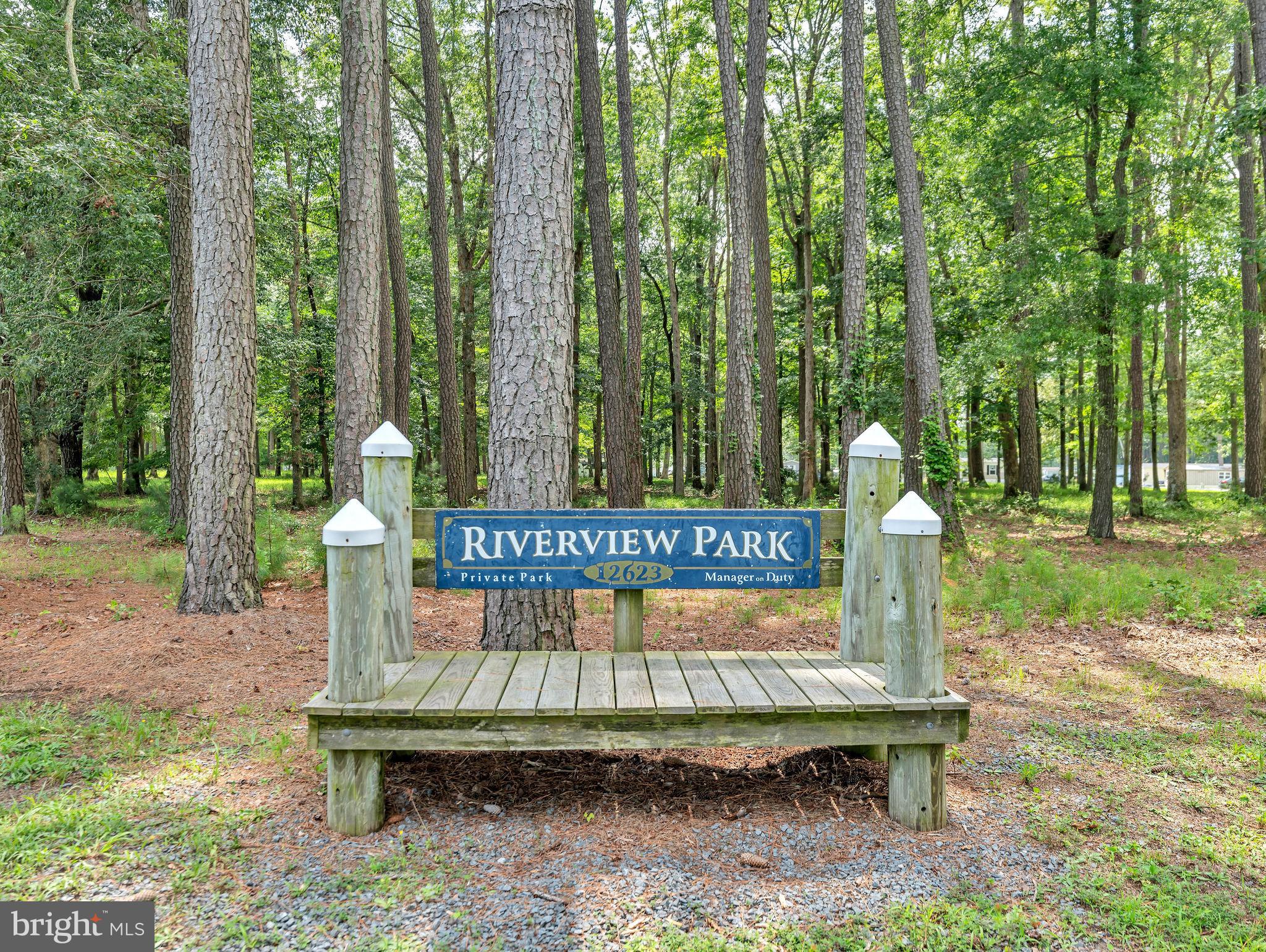 12623 Shell Mill Road, Unit 54 Bishopville, MD 21813 - Photo 20 of 24 a wooden bench sitting in the middle of a park