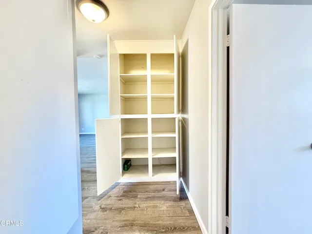 a view of a walk in closet with white walls