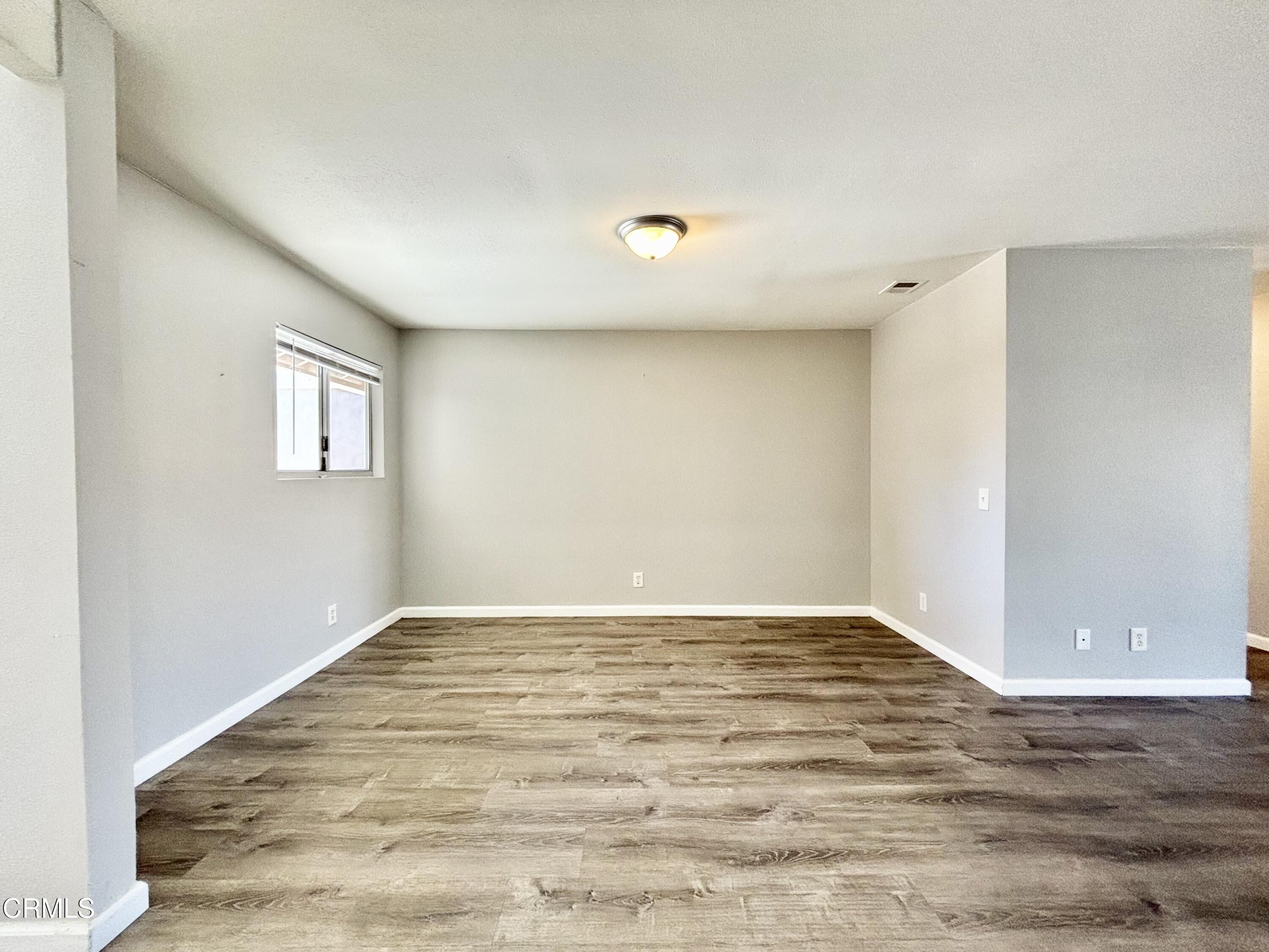 3604 Ketch Avenue Oxnard, CA 93035 - Photo 24 of 38 a view of an empty room with wooden floor and a window