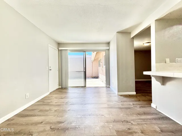 a view of an empty room with window and a bathroom