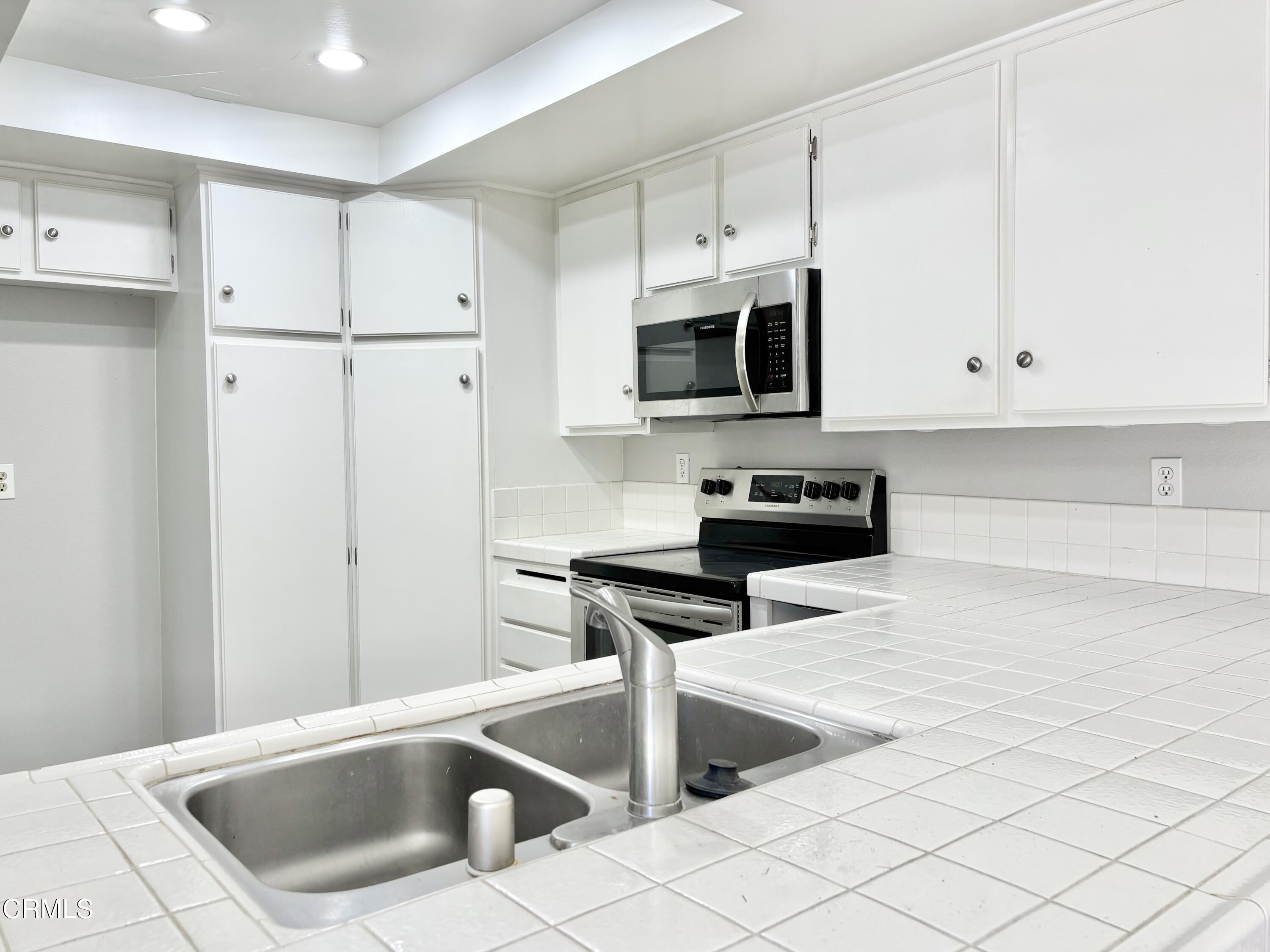 3604 Ketch Avenue Oxnard, CA 93035 - Photo 5 of 38 a kitchen with granite countertop white cabinets and stainless steel appliances