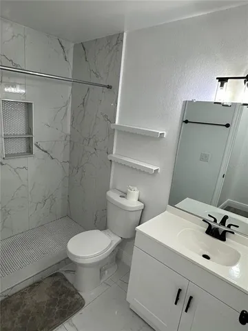 a bathroom with a sink a toilet and shower