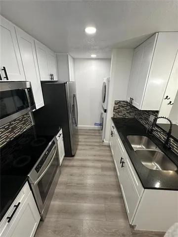 a kitchen with a sink and stainless steel appliances