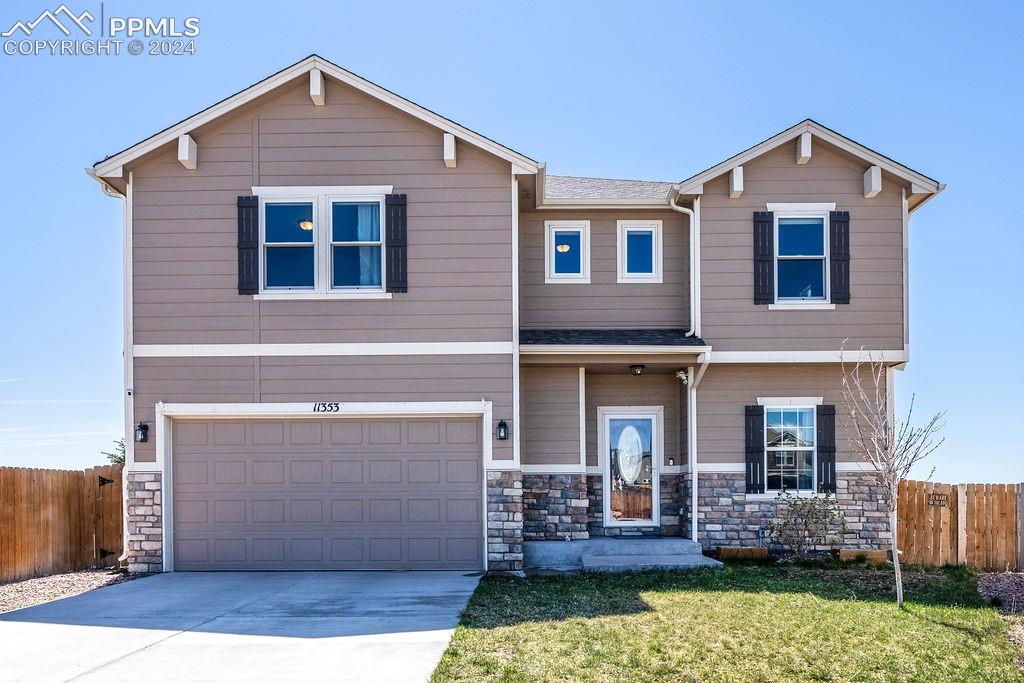 11353 Avena Road Peyton, CO 80831 - Photo 1 of 46 View of front of home featuring a garage and a front lawn