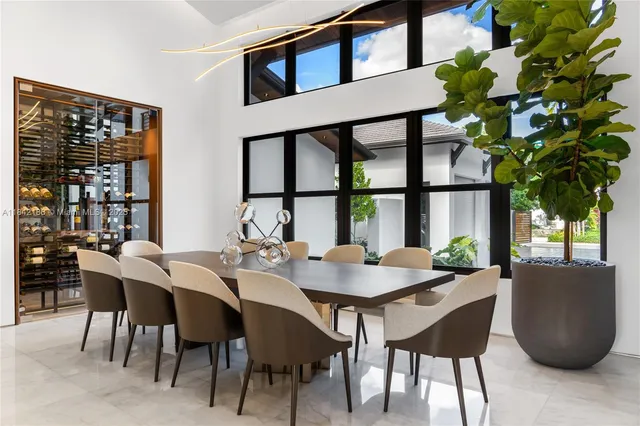 a living room with furniture large window and potted plants
