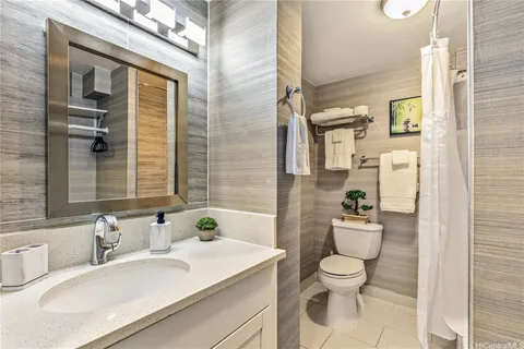 a bathroom with a granite countertop sink toilet a mirror and shower