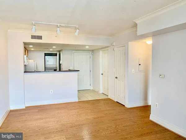 a view of a big room with wooden floor and windows