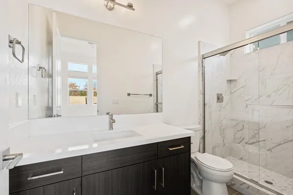 a bathroom with a sink a toilet and shower