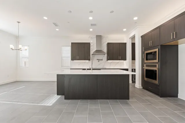 a large kitchen with stainless steel appliances a counter top a refrigerator and a sink
