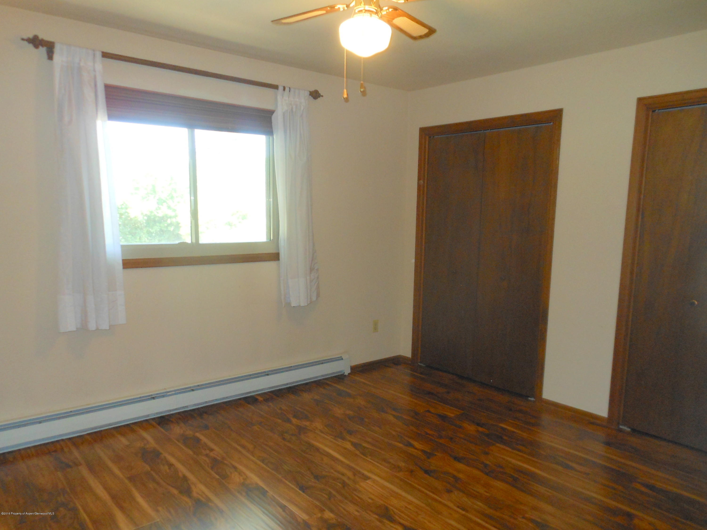 817 Cedar Drive Rifle, CO 81650 - Photo 12 of 24 an empty room with wooden floor and windows