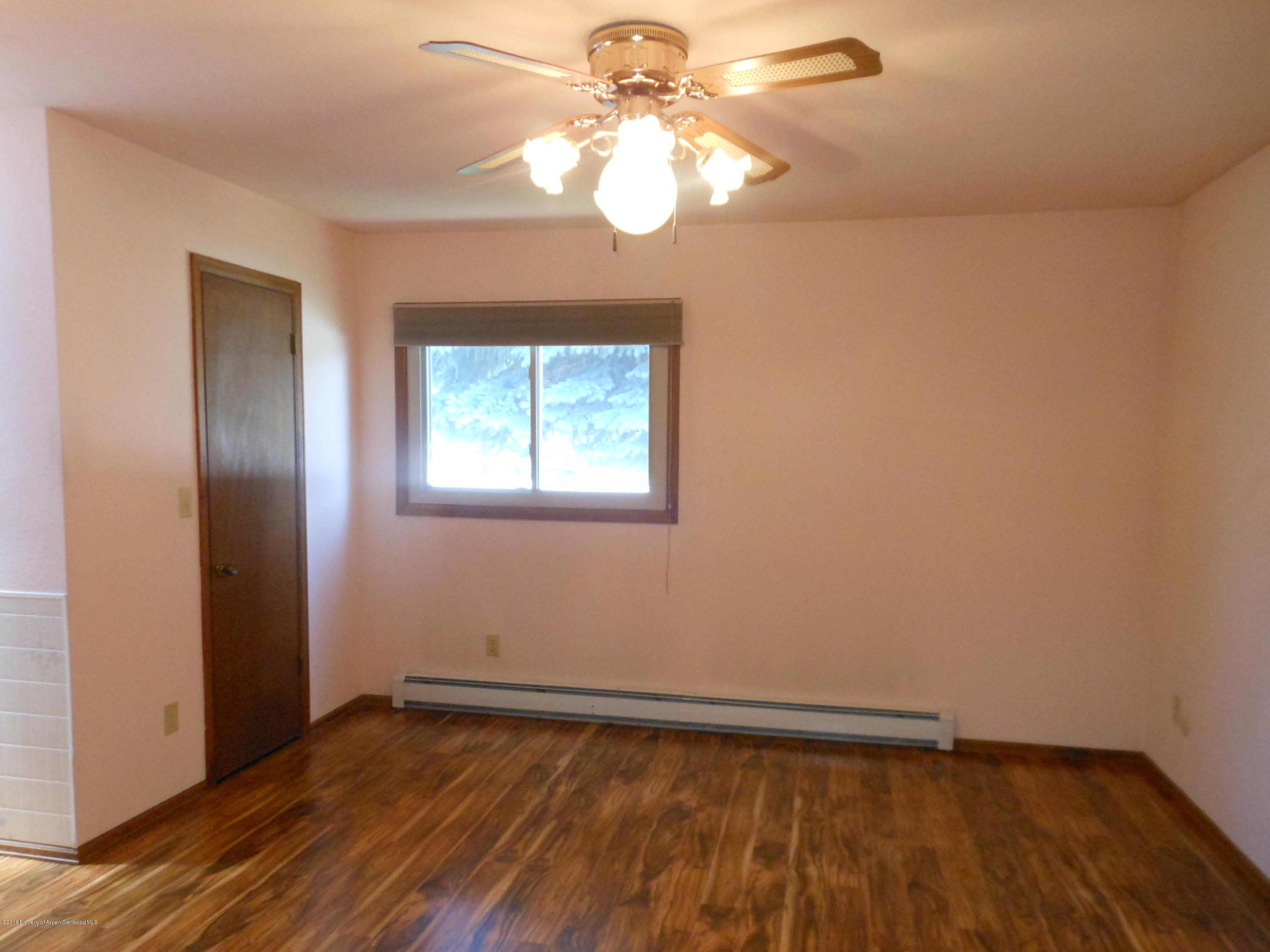 817 Cedar Drive Rifle, CO 81650 - Photo 13 of 24 a view of an empty room with wooden floor and a window