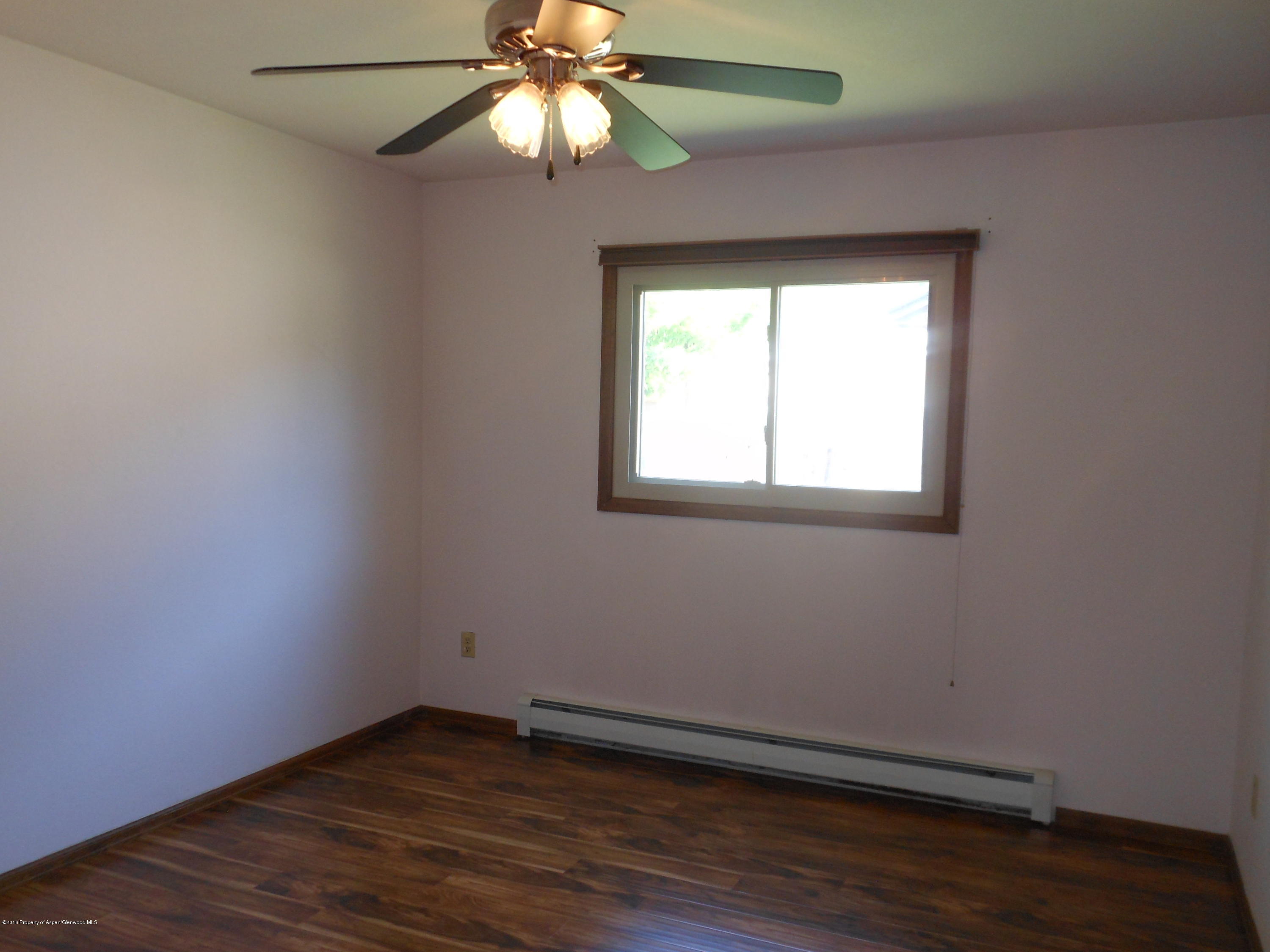 817 Cedar Drive Rifle, CO 81650 - Photo 14 of 24 an empty room with wooden floor fan and windows