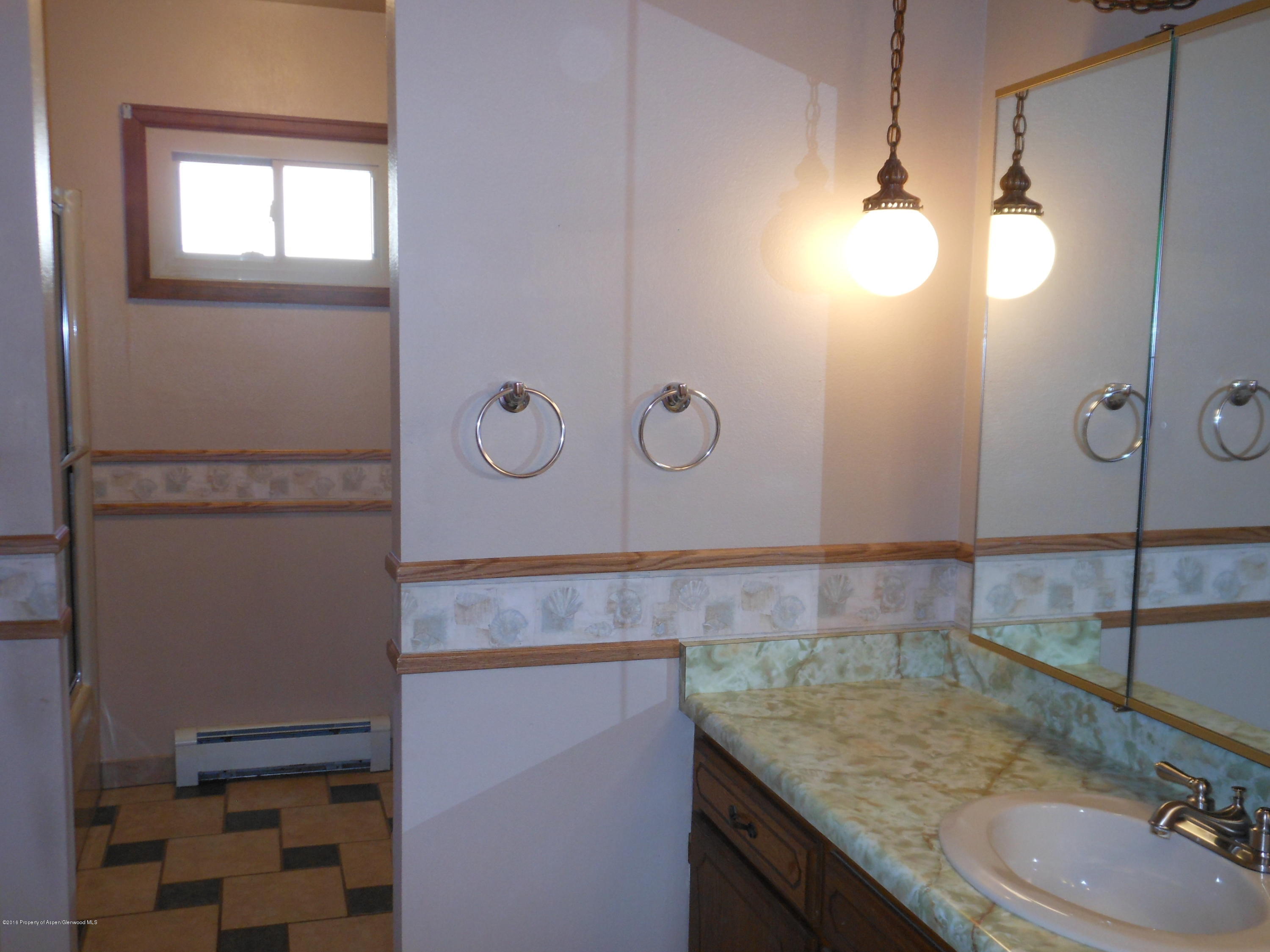 817 Cedar Drive Rifle, CO 81650 - Photo 15 of 24 a bathroom with a granite countertop sink and mirror
