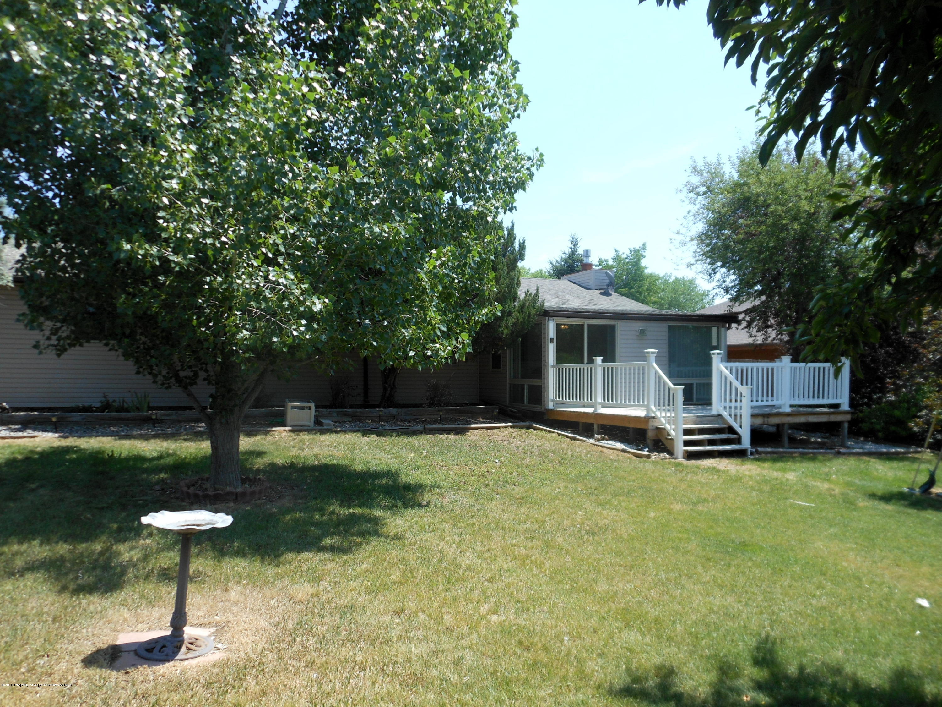 817 Cedar Drive Rifle, CO 81650 - Photo 23 of 24 a backyard of a house with barbeque oven and table and chairs