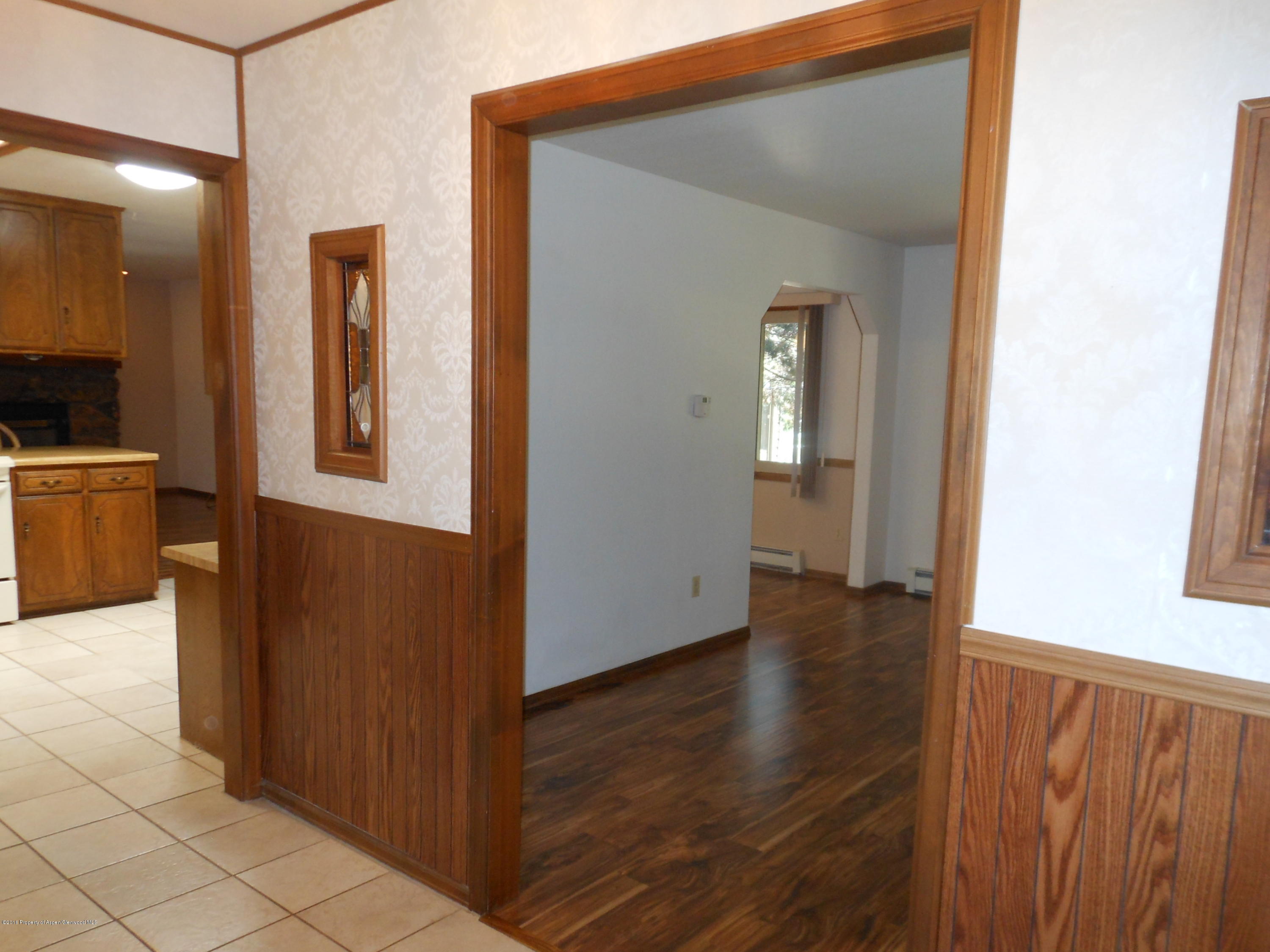 817 Cedar Drive Rifle, CO 81650 - Photo 5 of 24 a view of a hallway with wooden floor and a bathroom