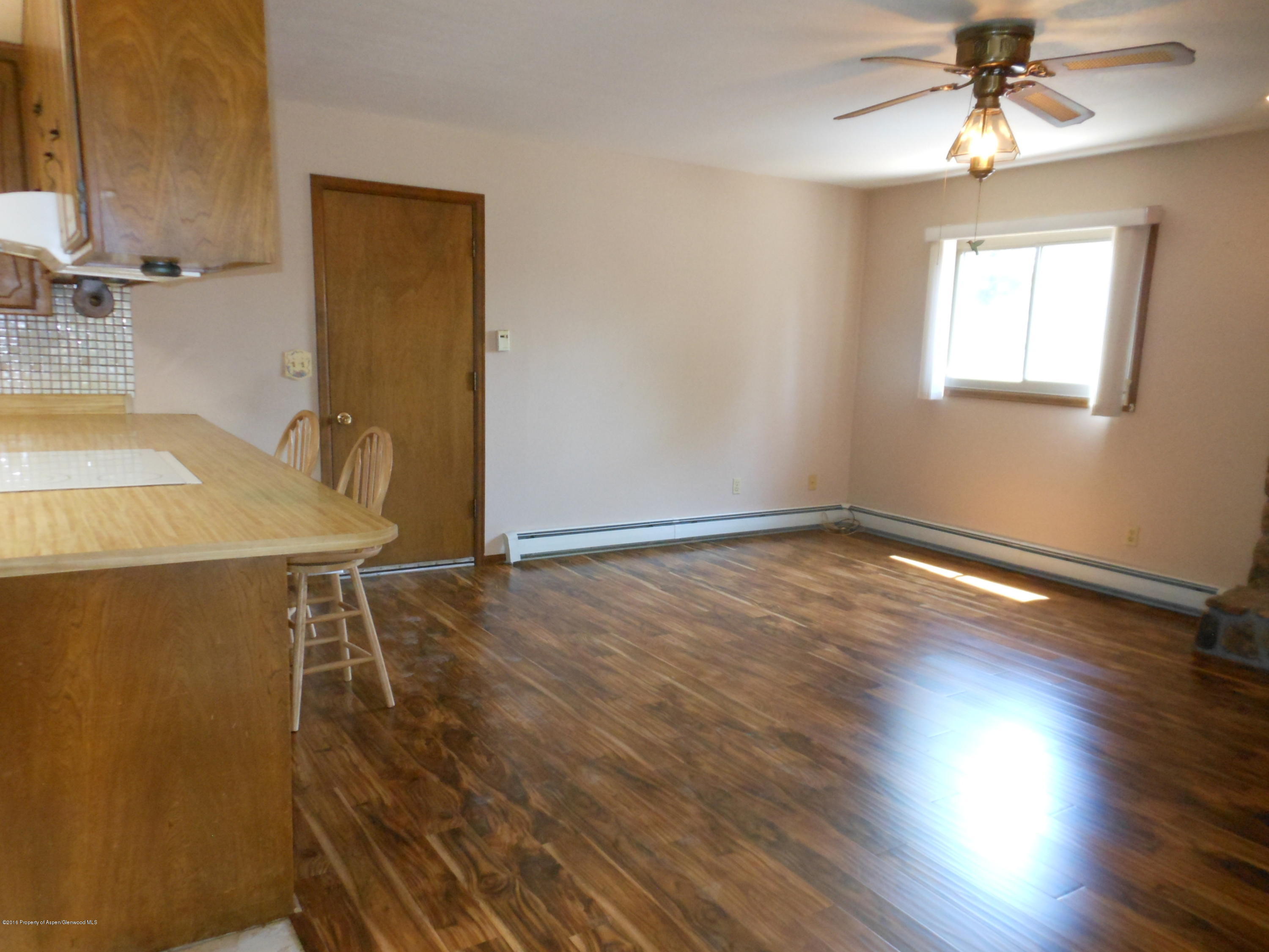 817 Cedar Drive Rifle, CO 81650 - Photo 6 of 24 a view of a livingroom with wooden floor and a ceiling fan