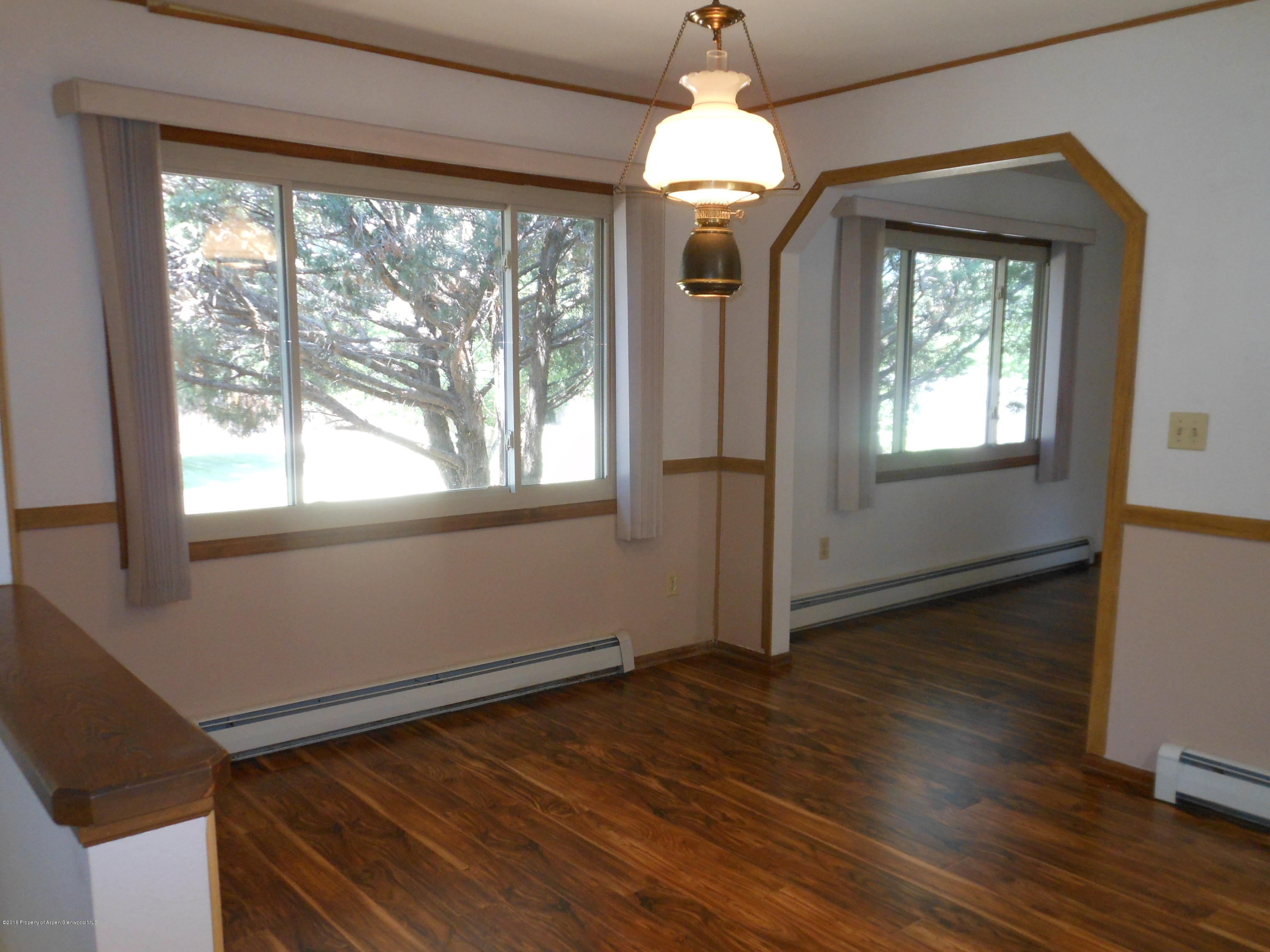 817 Cedar Drive Rifle, CO 81650 - Photo 7 of 24 an empty room with wooden floor fan and windows