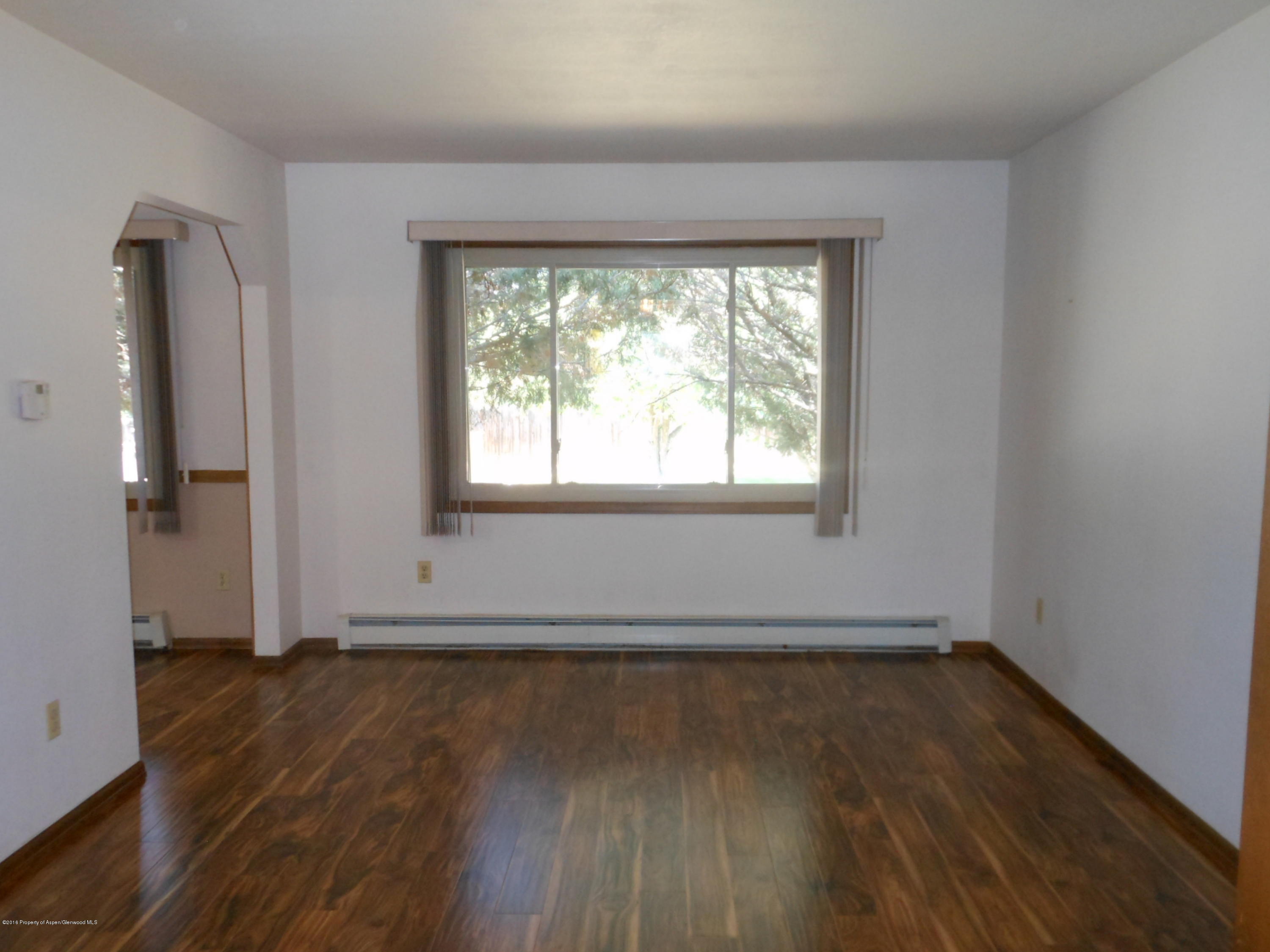 817 Cedar Drive Rifle, CO 81650 - Photo 8 of 24 an empty room with wooden floor and a window