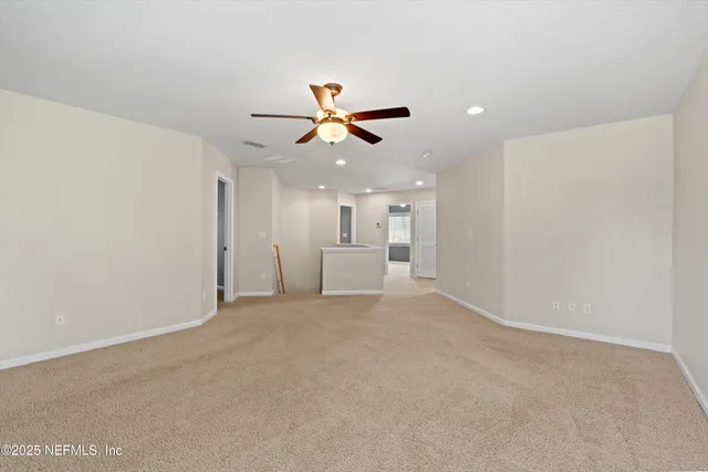 a view of a livingroom with a chandelier fan and fire place