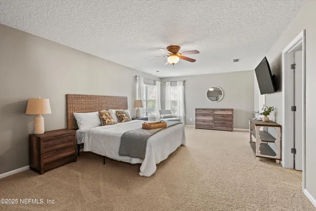 a spacious bedroom with a bed and a flat screen tv