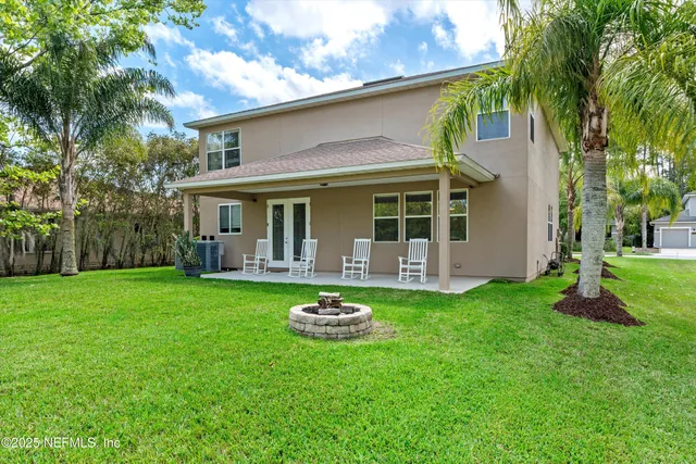 a view of a chair and table in backyard of the house