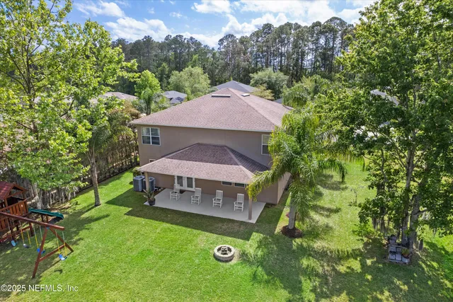an aerial view of a house with swimming pool and garden