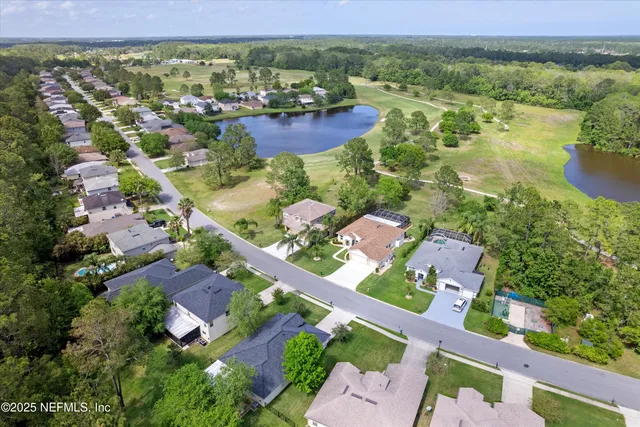 an aerial view of residential houses with outdoor space and river