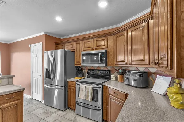 a kitchen with a refrigerator a sink and wooden cabinets
