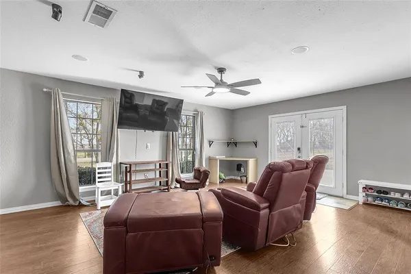 a living room with furniture a flat screen tv and wooden floor