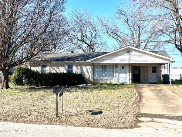a front view of a house with a yard covered with snow in front of house