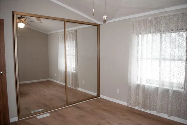 an empty room with windows and closet