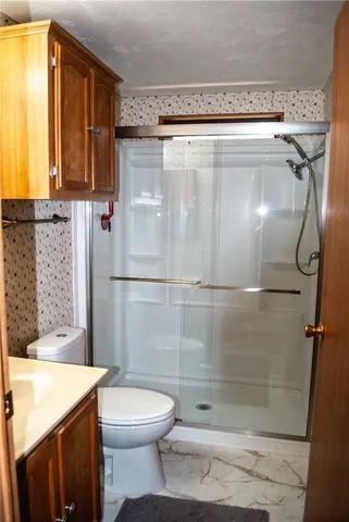 a bathroom with a shower a toilet and sink