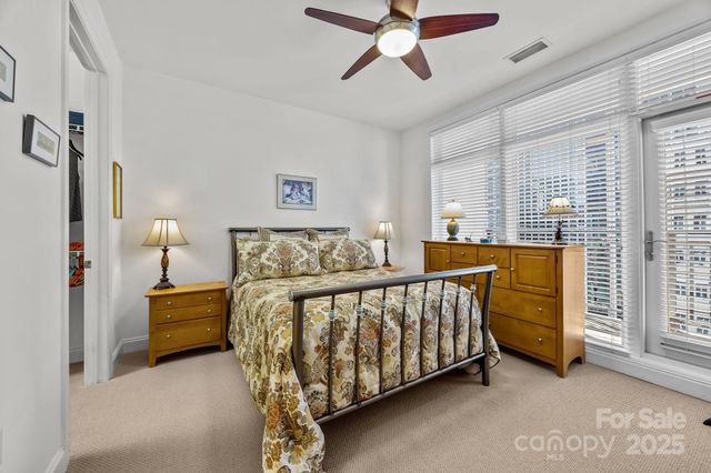 a bedroom with a bed and a chandelier fan