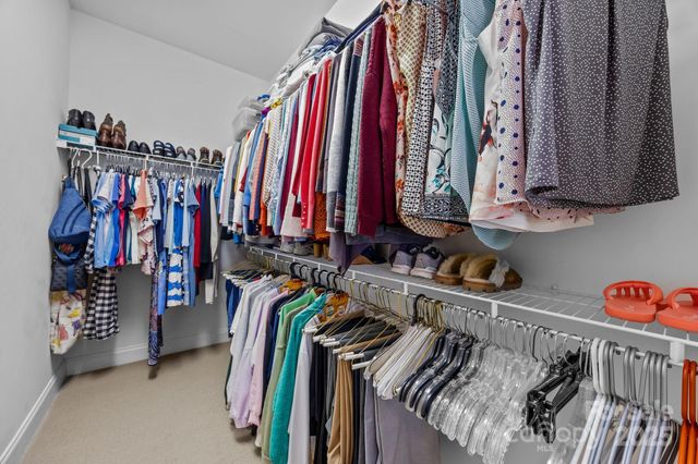 a view of walk in closet with clothes