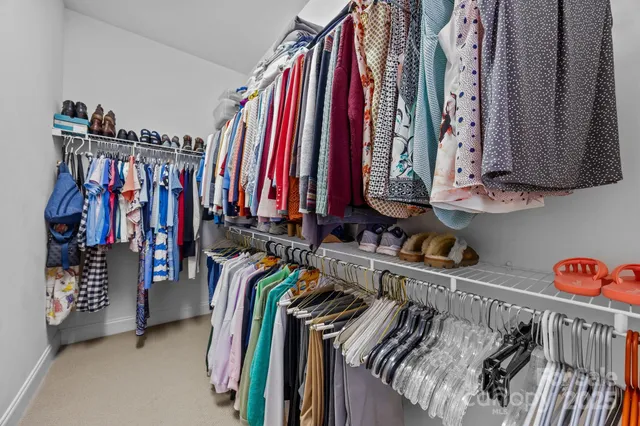 a view of walk in closet with clothes