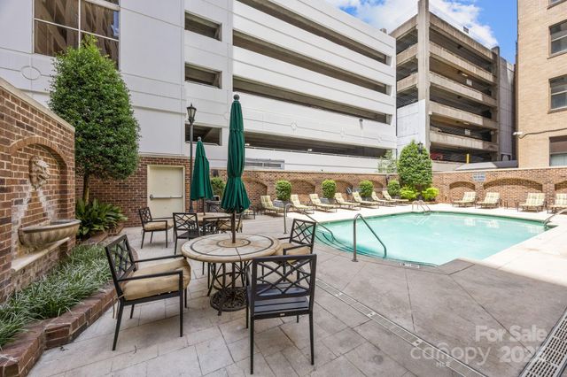 a view of a patio with couches table and chairs under an umbrella